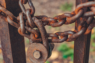 A rusty bolt lock on an old rusty chain on an iron gate. Left space concept or abandoned area.