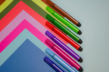 Creative geometric composition with colorful felt-tip pens and colored paper.