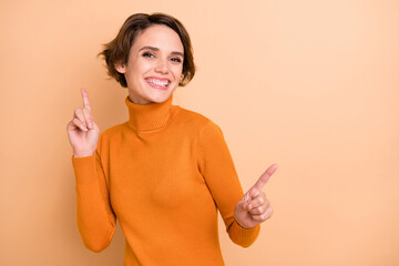 Photo of young attractive pretty smiling happy positive cheerful girl with short hair dancing isolated on beige color background