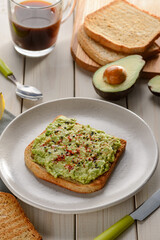 Toast with mashed avocado, sesame seeds, paprika and salt