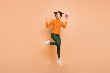 Fototapeta na wymiar Full size photo of young beautiful excited smiling happy positive girl jump with passport in hand isolated on beige color background