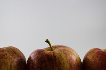 Close up of parts of three apples isolated on white