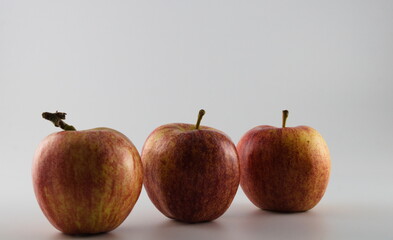Three red and yellow apples diagonally lined isolated on white