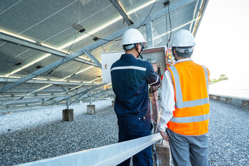 Workers use clamp meter to measure the current of electrical wires produced from solar energy for...