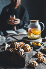 Woman is sitting with Hot tea with fresh grapefruit on wooden tablet. Healthy drink, Eco, vegan.