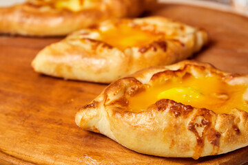 Ajarian traditional flatbread khachapuri or hachapuri with cheese, egg and butter on a plate