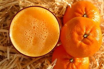 Bright freshly squeezed juice from oranges and tangerines with citrus fruits laid out decoratively, top view