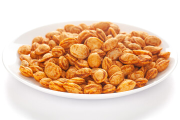 Roasted Crunchy Peanuts in a white ceramic square plate, made with peanuts. Pile of Indian spicy snacks (Namkeen), under backlight, side view