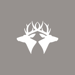 two deer heads logo. vector flat silhouette isolated on beige background. Wild animal symbol.