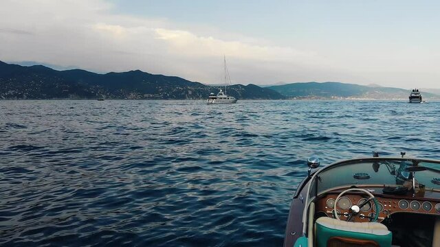 AERIAL: drone flies down above the waves pattern to reveal classic italian speedboat dashboard - riva aquarama