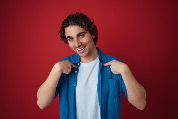 Joyful handsome man smiling and pointing fingers at himself