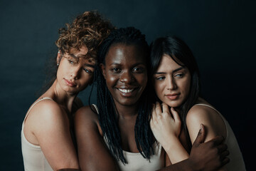 Three girls from different ethnicities posing in studio for a 