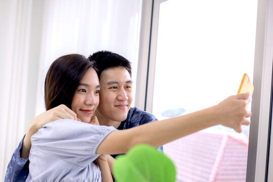 Asian couple making a selfie at hotel room by smartphone. Asian couples taking selfies at resort room. Journey, Travel concept. Honeymoon trip