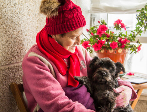 Warm Senior Woman Sitting With Her Dog At Home