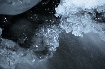 clean ice shapes with freezing river stream underneath
