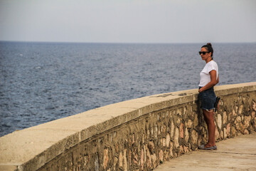 Fototapeta na wymiar latin girl in a gazebo by the sea and with sunglasses 