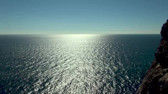 View of calm sea from observation deck of Swallow's Nest Castle on the forty-meter Avrora rock. Sun's rays are reflected from emerald surface of black sea water. Beauty of wild Crimean nature.