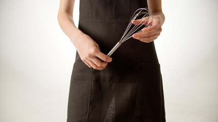 Chef, cook or baker woman. Female hand with a kitchen whisk