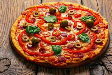 Delicious pizza served on wooden plate