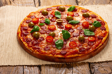 Delicious pizza served on wooden plate