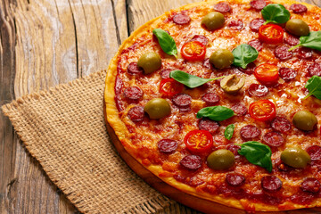 Delicious pizza served on wooden plate