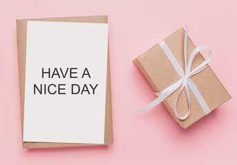 Gifts with note letter on isolated pink background, love and valentine concept with text HAVE A NICE DAY