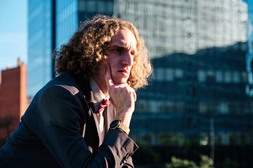 Portrait of stylish man looking aside and touching his chin