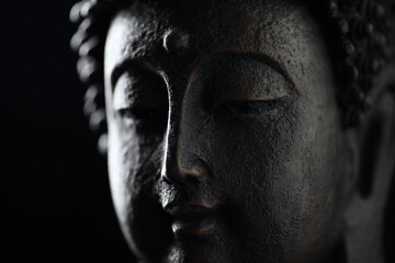 Meditating Buddha Statue on black background.	