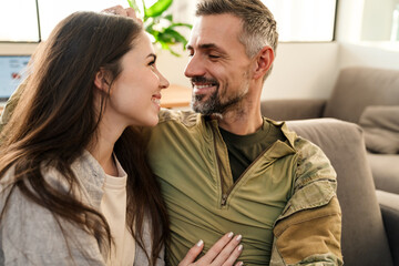 Smiling military couple relaxing at home