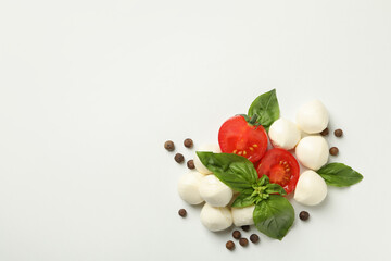 Mozzarella, basil, tomato and pepper on white background, space for text