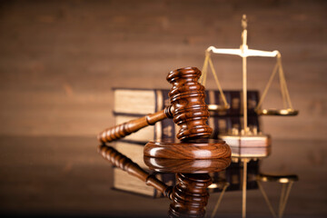 Law symbols composition on brown background. Gavel, scale, legal books and Themis sculpture. Place...
