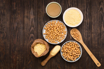 Cooked Chickpeas, aquafaba, chickpea flour on dark wooden background.