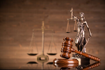 Law symbols composition on brown background. Gavel, scale, legal books and Themis sculpture. Place...