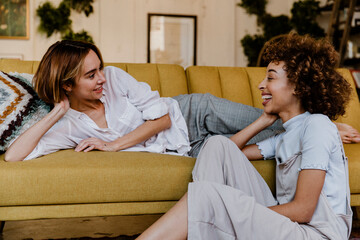 Cheerful lesbian couple talking in a living room - Powered by Adobe