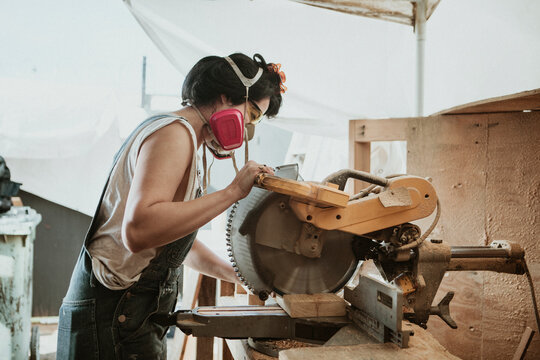 Female carpenter using a compound miter saw
