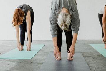 Sporty people practicing Uttanasana pose