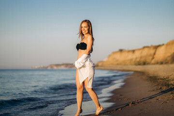 Naklejka premium Pretty brunette woman relaxing on the beach at the sea.