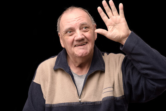 portrait vieil homme disant au revoir de la main sur fond noir