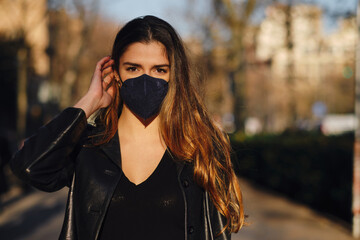 Woman wearing a face mask while standing outdoors.