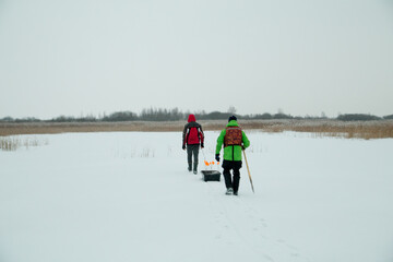 two fishermen with sledges on a winter fisherman