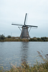 Dutch traditional landscape with old windmills in kinderdijk, Rotterdam, channel and water ways, green grass