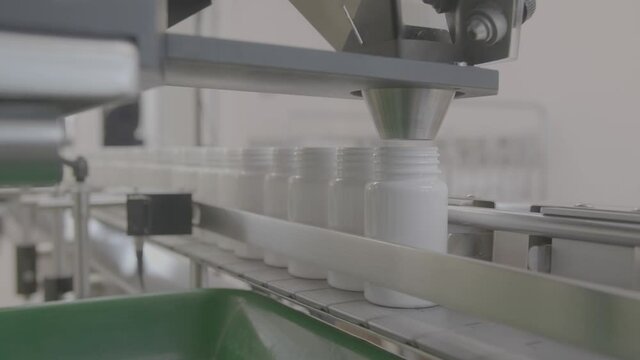 Medical Production for Drugs Supply of Pharmacy Industry Closeup. Manufacturing Plastic Bottle Row on Conveyor Line of Pharmaceutical Factory. Pills Packaging shot in V-log