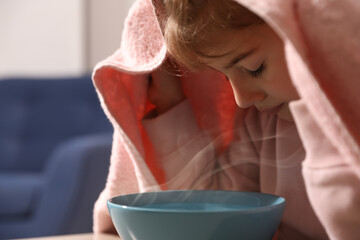 Little girl covering head with towel and inhaling steam indoors, closeup - obrazy, fototapety, plakaty