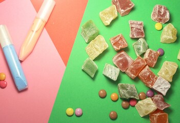 sweets and paints on a green-pink background