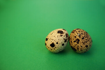 Obraz premium two raw quail eggs lie on a green background on the side . healthy food