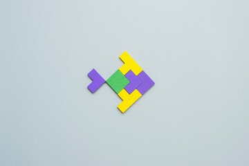 Obraz premium Fish shape block of colorful wood puzzle piece on gray background. logical thinking, business logic, Conundrum, decision, solutions, rational, mission, success, goals and strategy concepts