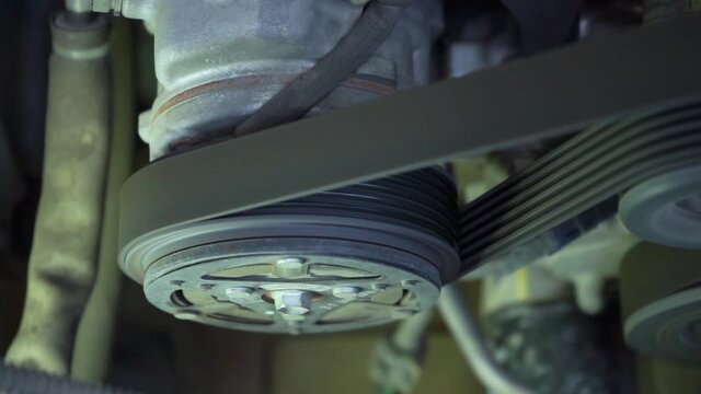 Close up detail of the engine  fragment are working by the air conditioner compressor starting runing and then stop.