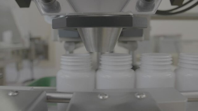 Medical drug plastic bottle transfer on Automated conveyor systems, pharmacy pills packing, industrial automation for package shot in V-log