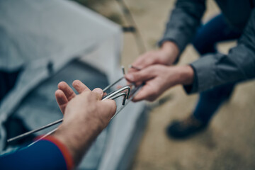 Two hikers adjusting a tent.