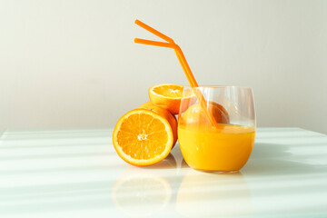 Orange juice in a glass with some oranges around